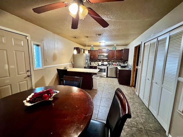 tiled dining room with visible vents and a textured ceiling