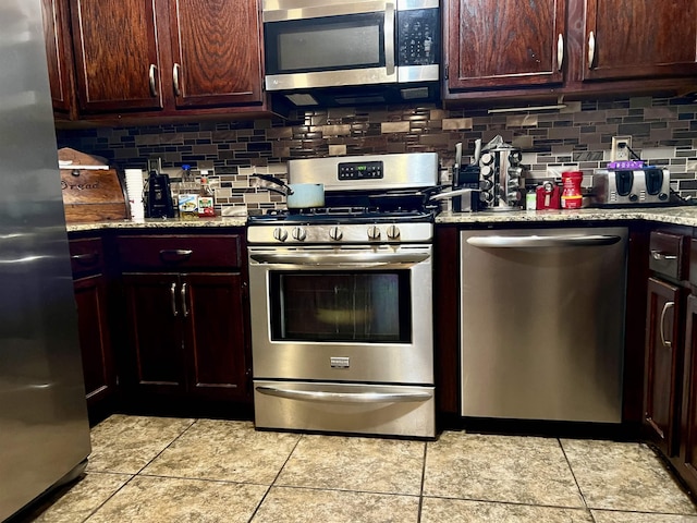 kitchen with light stone countertops, tasteful backsplash, and appliances with stainless steel finishes