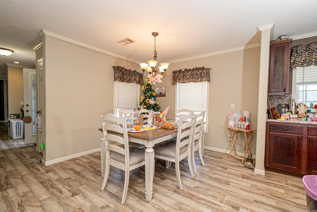 dining room with visible vents, crown molding, light wood finished floors, and an inviting chandelier