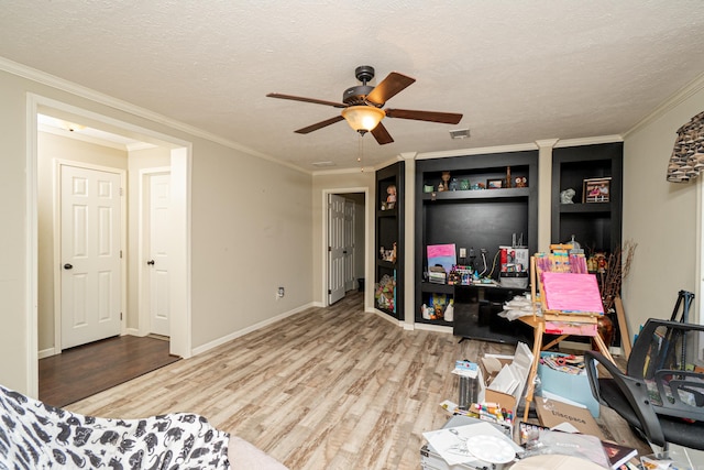 office area featuring crown molding, ceiling fan, a textured ceiling, wood finished floors, and baseboards