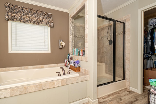 bathroom featuring a bath, a stall shower, a spacious closet, and crown molding