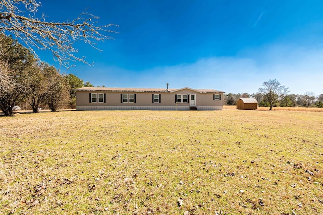 back of property featuring an outbuilding, a yard, and a storage unit