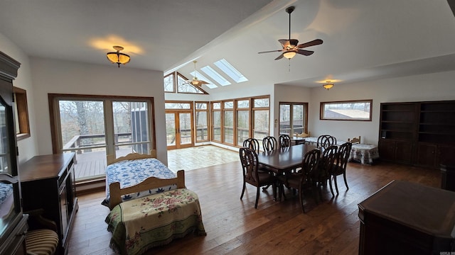 dining area featuring ceiling fan, high vaulted ceiling, dark wood-style flooring, and a skylight