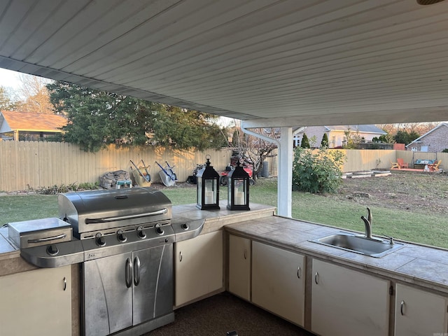 view of patio featuring a fenced backyard, a sink, and area for grilling