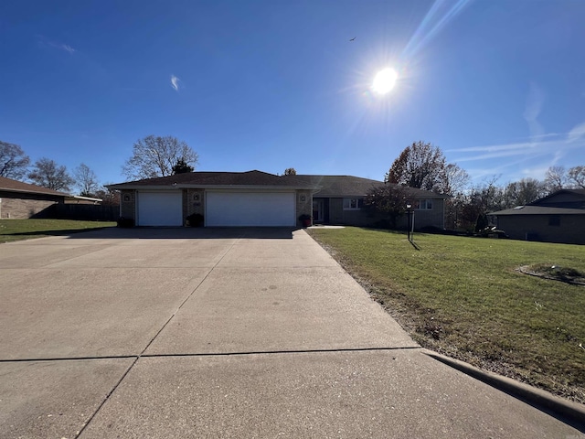 ranch-style home featuring a garage, brick siding, driveway, and a front lawn