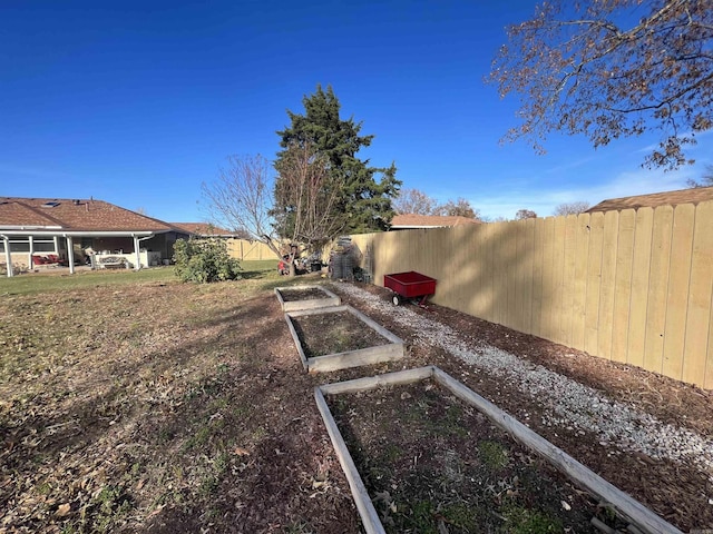 view of yard with a garden and a fenced backyard