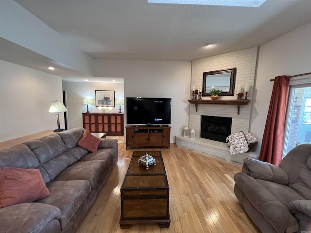 living room featuring light wood-style floors, recessed lighting, and a fireplace