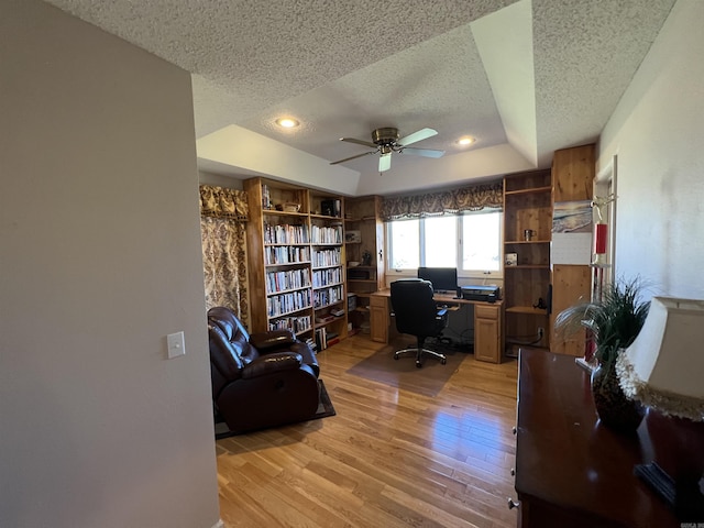 office area featuring a ceiling fan, light wood-style flooring, a tray ceiling, a textured ceiling, and recessed lighting