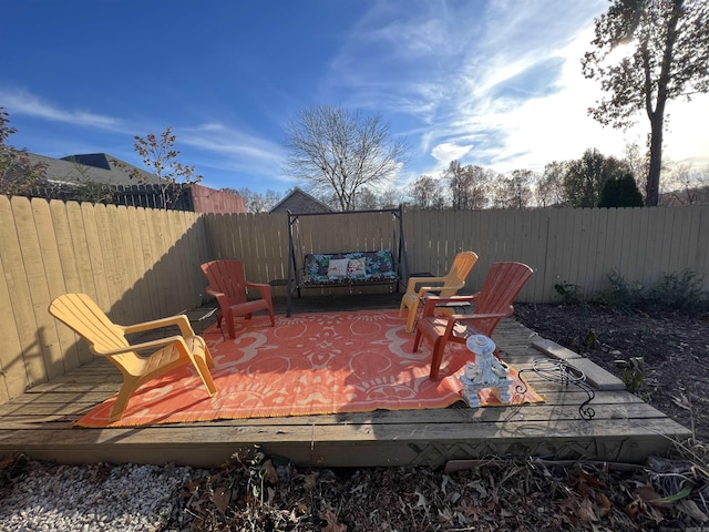 wooden deck with a fenced backyard