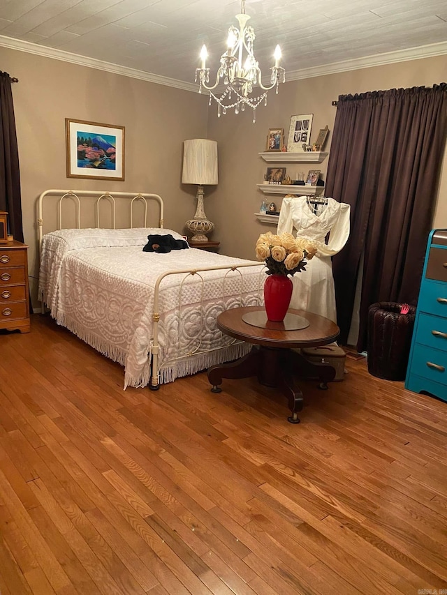 bedroom featuring a notable chandelier, crown molding, and wood finished floors