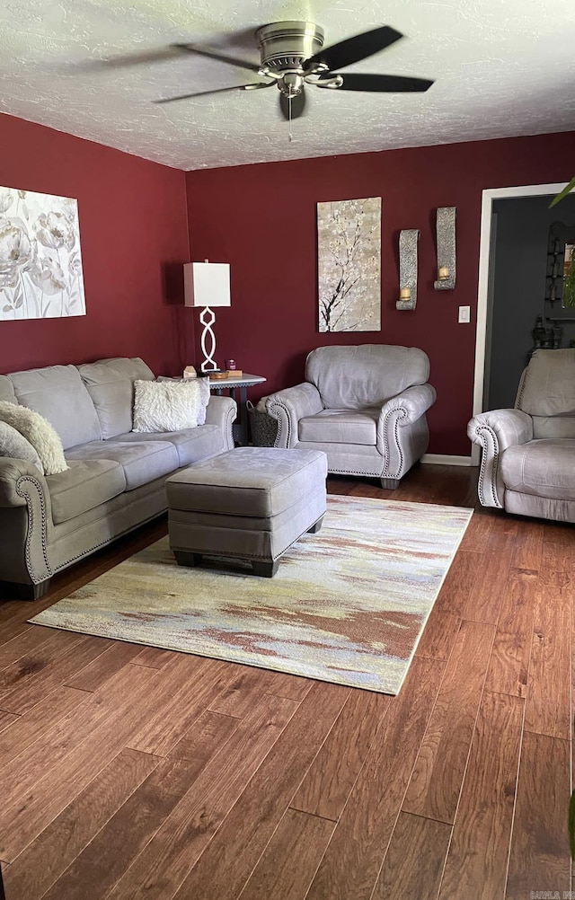 living area featuring a textured ceiling, ceiling fan, and hardwood / wood-style flooring