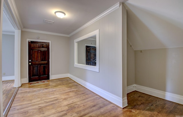 foyer with ornamental molding, baseboards, visible vents, and light wood finished floors