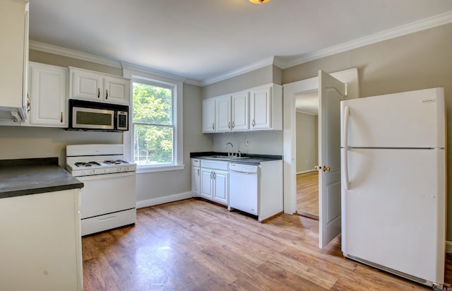 kitchen with dark countertops, white appliances, ornamental molding, and white cabinets