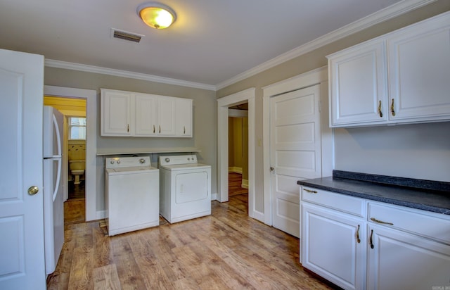 washroom with independent washer and dryer, cabinet space, visible vents, and crown molding