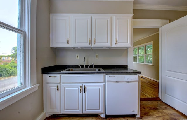 kitchen featuring dishwasher, dark countertops, a sink, and white cabinetry