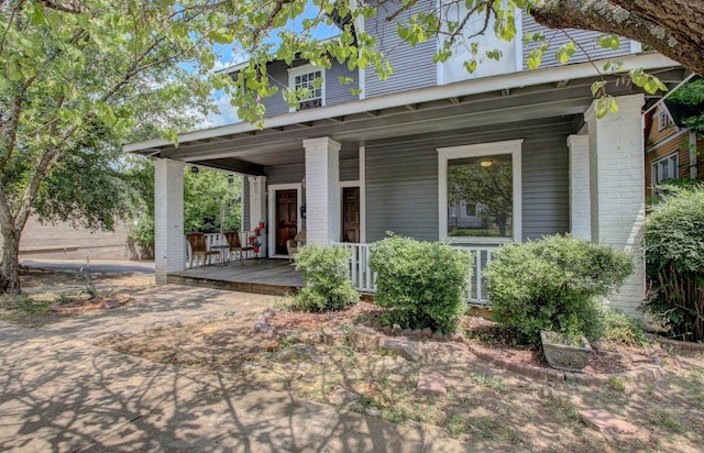 view of front of house featuring a porch and brick siding