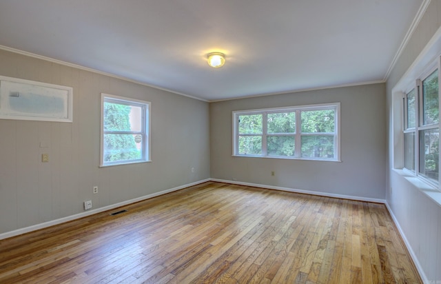 spare room with ornamental molding, hardwood / wood-style floors, visible vents, and baseboards