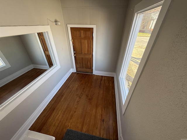 hallway with dark wood-style floors and baseboards