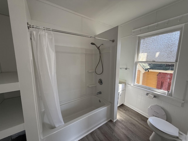 full bath with tile walls, wood finished floors, toilet, and shower / tub combo with curtain