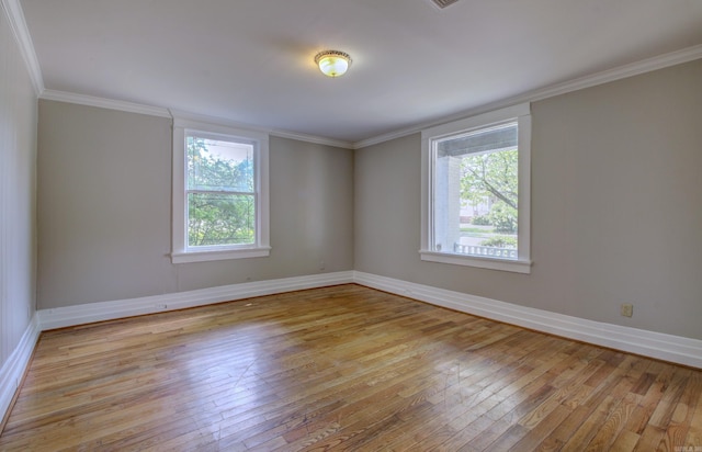 spare room featuring light wood-style floors, ornamental molding, and baseboards