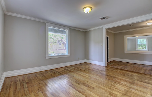 spare room with baseboards, light wood-type flooring, and crown molding