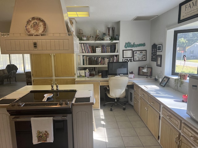 home office featuring light tile patterned floors, built in desk, and visible vents