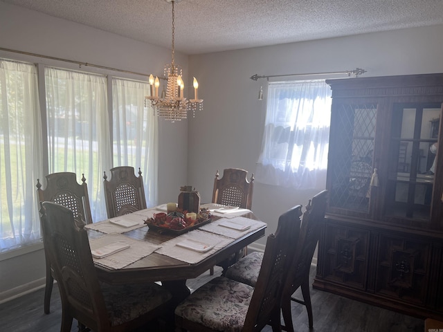 dining room with a notable chandelier, baseboards, a textured ceiling, and wood finished floors