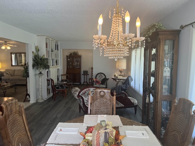 dining area with ceiling fan with notable chandelier, a textured ceiling, and wood finished floors