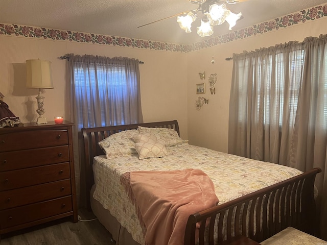 bedroom with dark wood finished floors, a textured ceiling, and ceiling fan