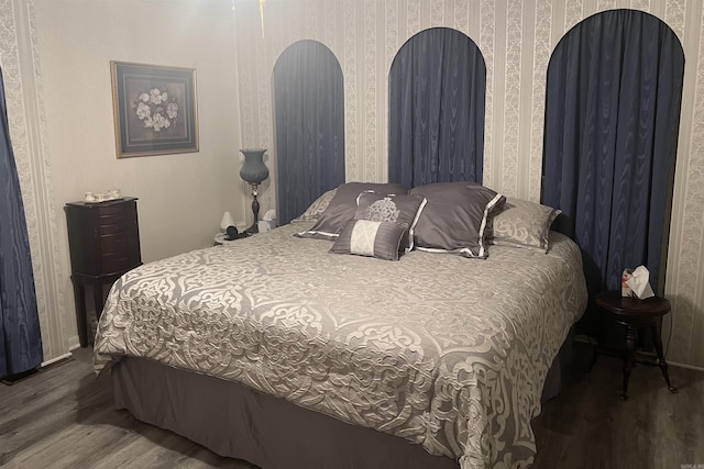 bedroom with wood finished floors and wallpapered walls