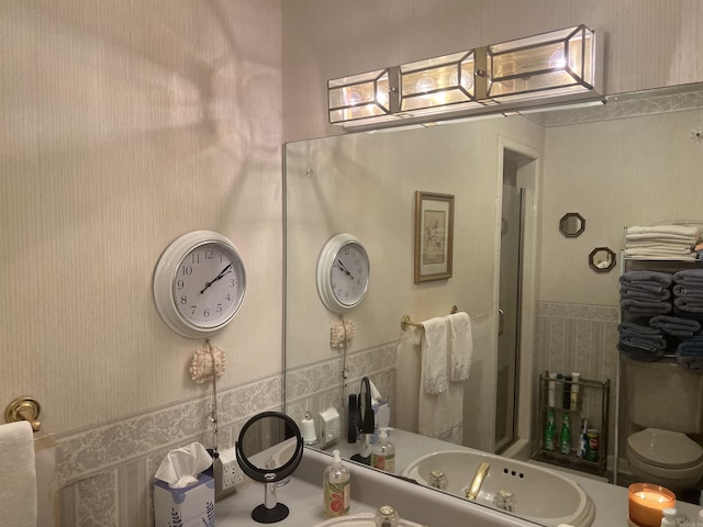 full bath featuring a shower with shower door and a sink