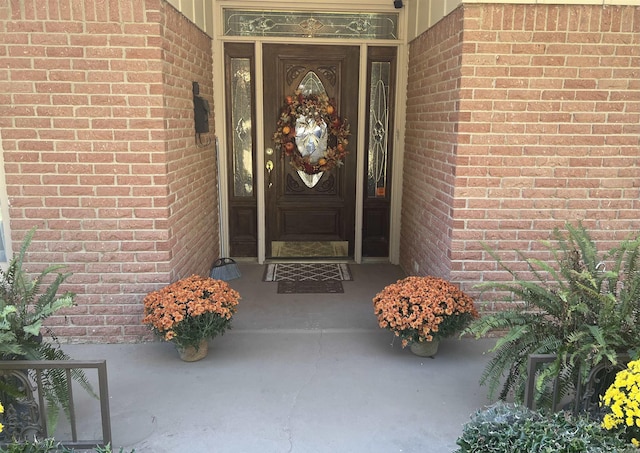 doorway to property featuring brick siding