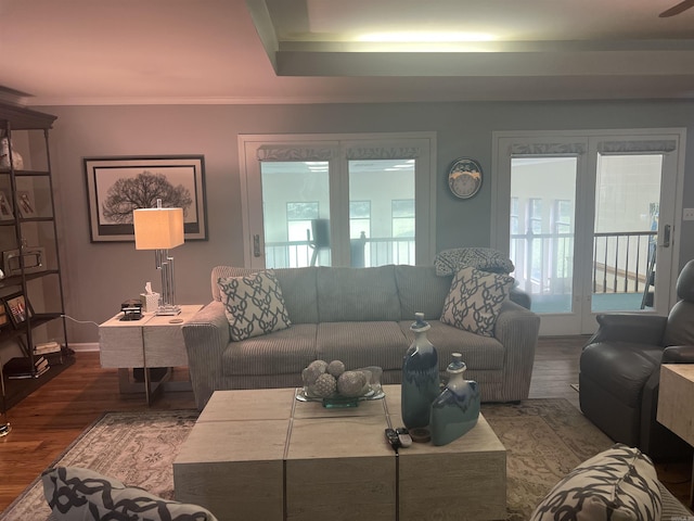 living area with baseboards, wood finished floors, and crown molding