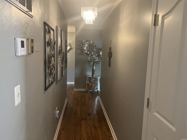 hallway with an inviting chandelier, crown molding, baseboards, and wood finished floors