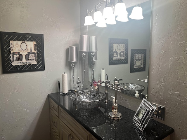 bathroom with a textured wall and vanity