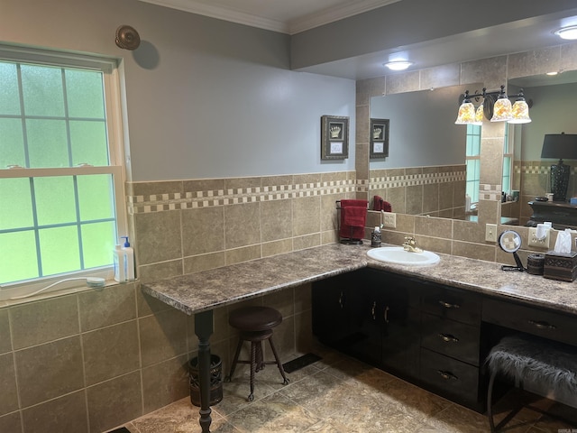 bathroom featuring a healthy amount of sunlight, crown molding, tile walls, and vanity