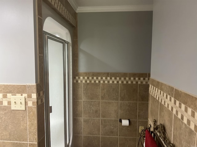 bathroom with ornamental molding, wainscoting, and tile walls