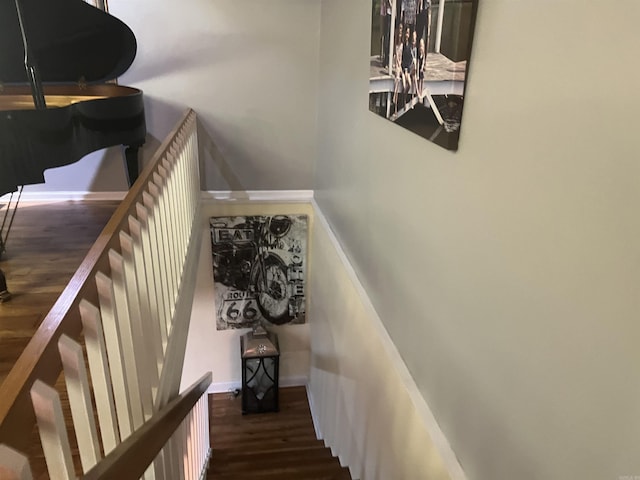 stairs featuring wood finished floors and baseboards