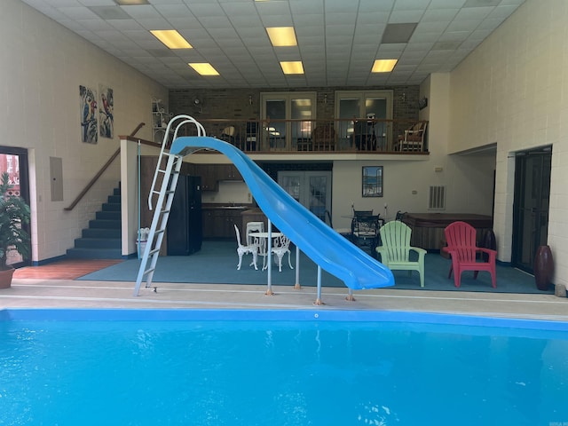 view of swimming pool featuring a pool, a water slide, a patio area, and a jacuzzi