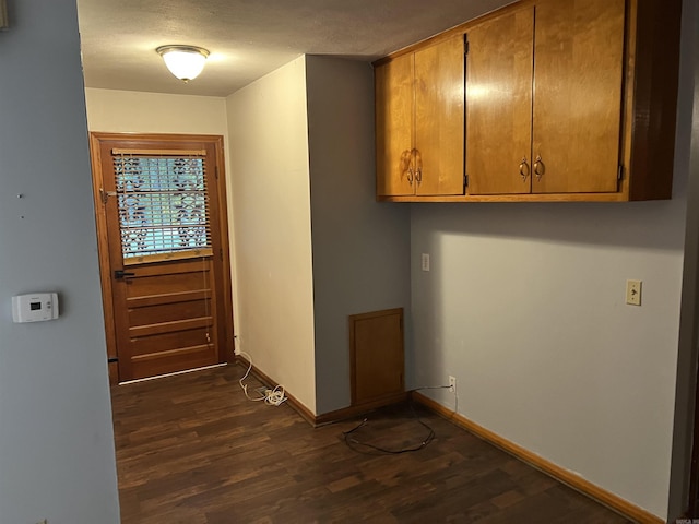 entryway featuring a textured ceiling, dark wood finished floors, and baseboards