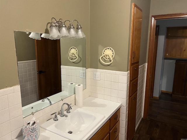 bathroom featuring a wainscoted wall, vanity, wood finished floors, and tile walls