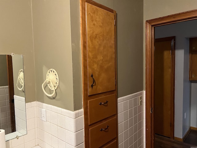 bathroom featuring wainscoting and tile walls