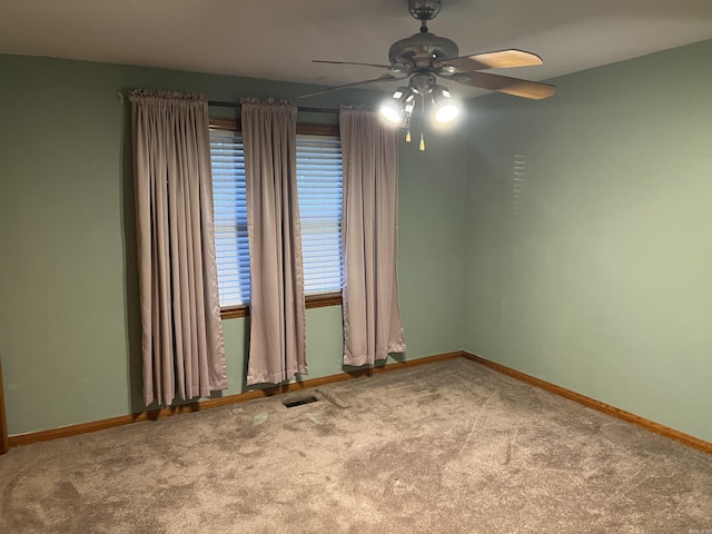 spare room featuring a ceiling fan, baseboards, visible vents, and carpet flooring