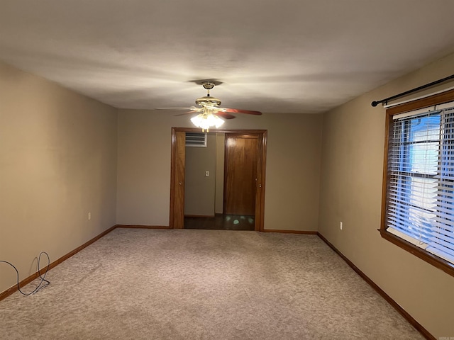 empty room with ceiling fan, baseboards, and light colored carpet