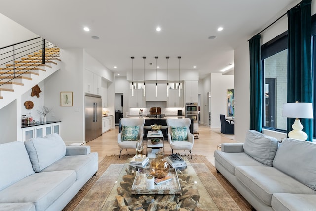 living area with light wood-style floors, stairway, and recessed lighting