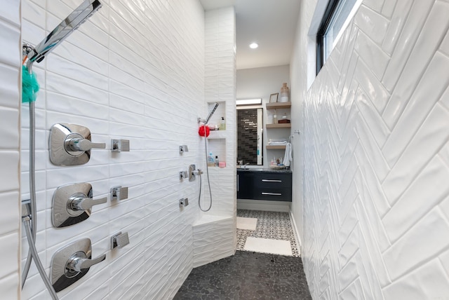 bathroom with tiled shower, vanity, and tile patterned floors