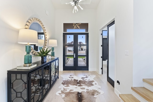 entryway featuring stairs, french doors, wood finished floors, and baseboards