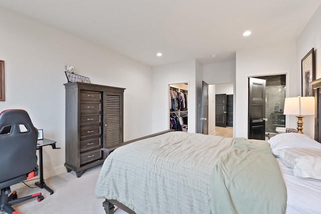 bedroom featuring recessed lighting, light carpet, baseboards, a closet, and a walk in closet