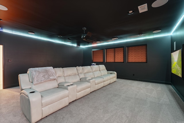 carpeted home theater room with a ceiling fan and visible vents