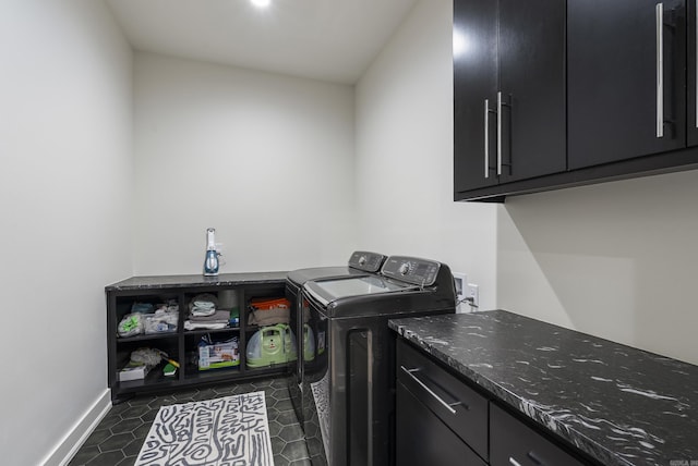 laundry area with dark tile patterned floors, independent washer and dryer, cabinet space, and baseboards